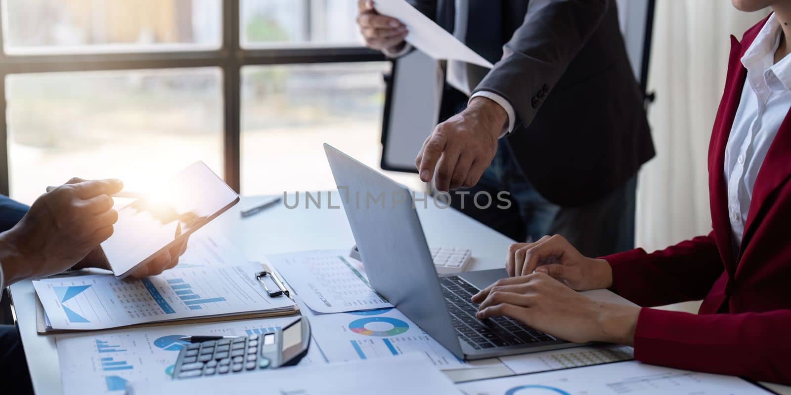 Team of business investment consultant analyzing company annual financial report working with documents pie and donut chart, using laptop and tablet, Business and Financial concept by nateemee