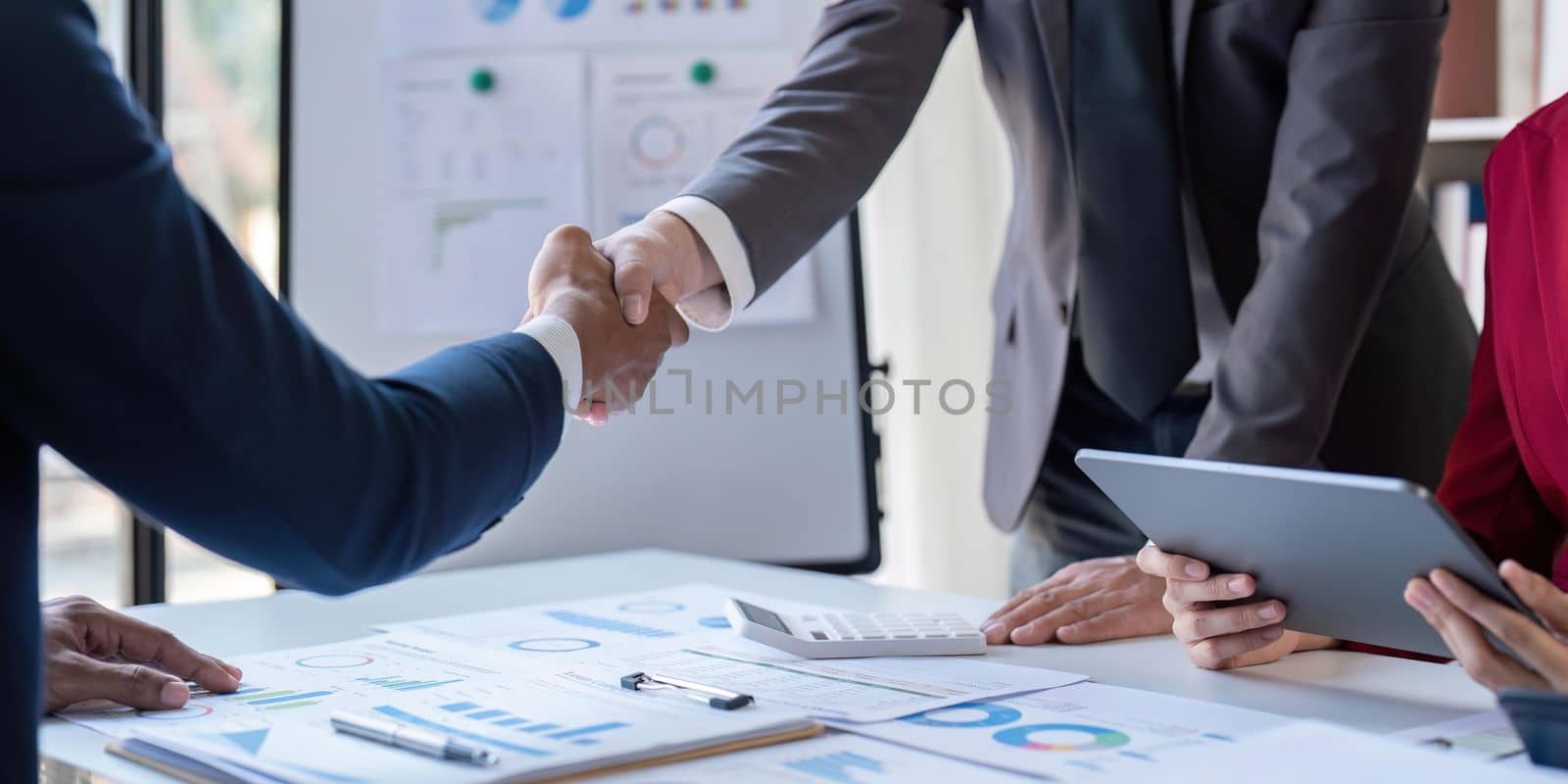 Shaking hand business leaders talk about charts, financial graphs showing results are analyzing and calculating planning strategies, business success building processes by nateemee