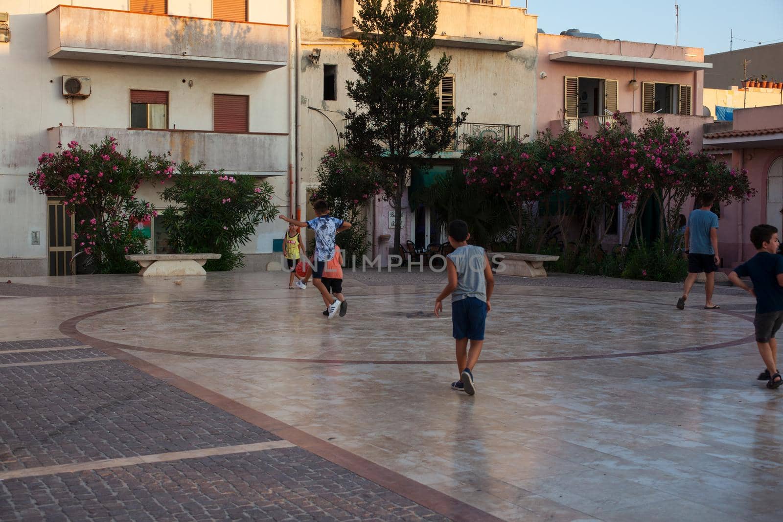 LAMPEDUSA, ITALY - AUGUST, 03: Children play soccer in the Lampedusa square on August 03, 2018