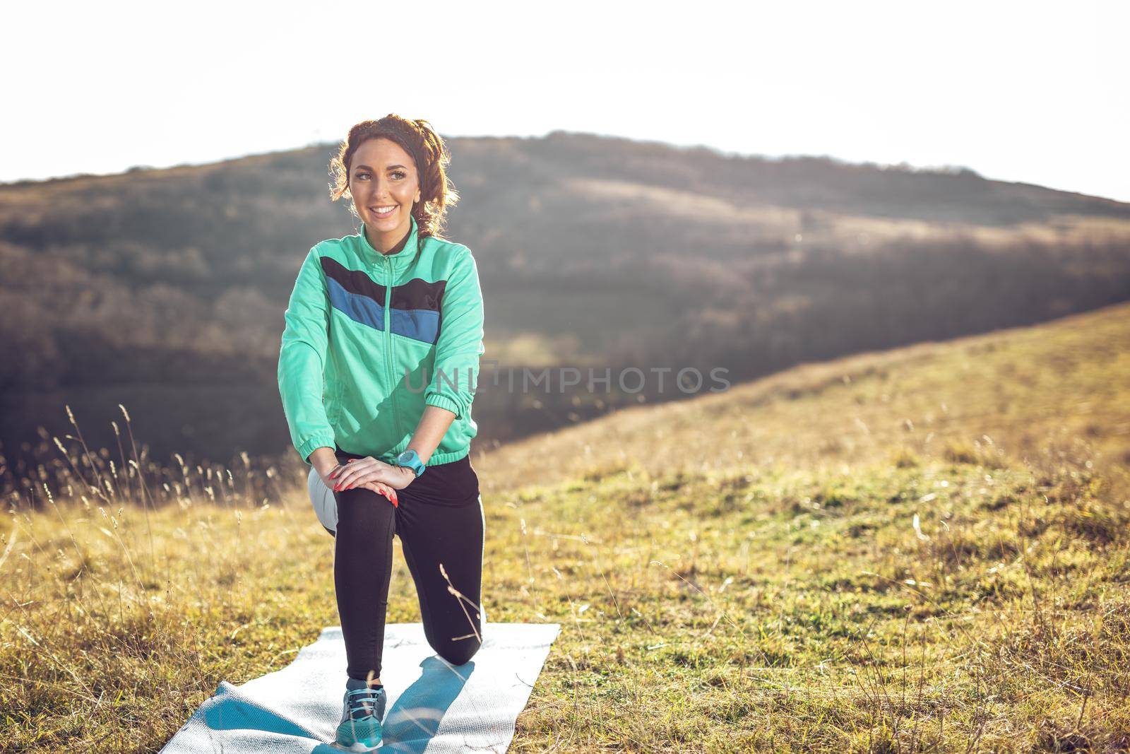 Young fitness woman doing stretching exercise after jogging in the nature.