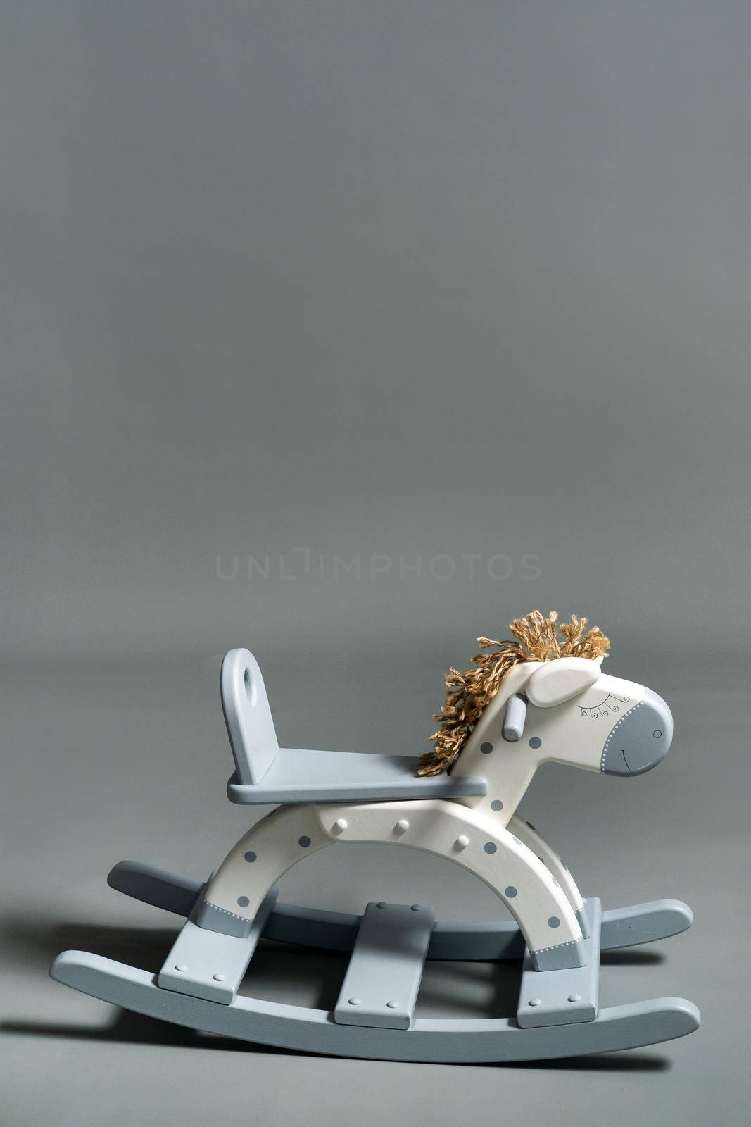 Handmade rocking horse on a gray background.