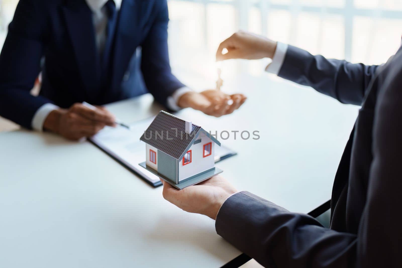 Real estate company to buy houses and land are delivering keys and houses to customers after agreeing to make a home purchase agreement and make a loan agreement. by Manastrong