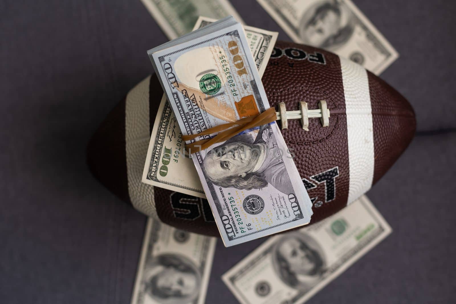 Football ball and money on gray background by Andelov13