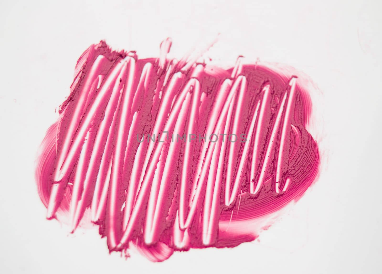 line of red lipstick smeared on white background