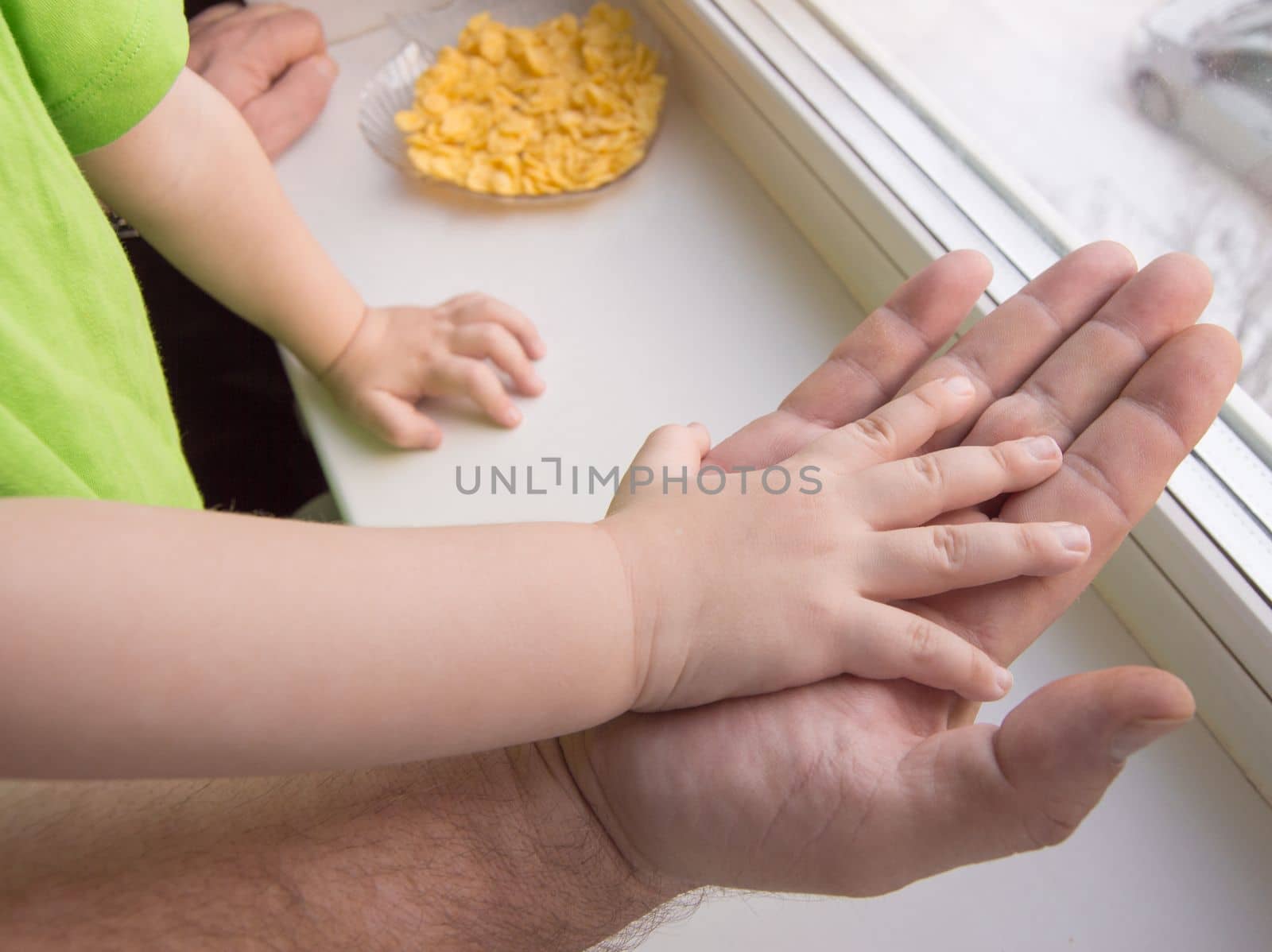 The child's hand rests on the palm of an adult male, child protection.
