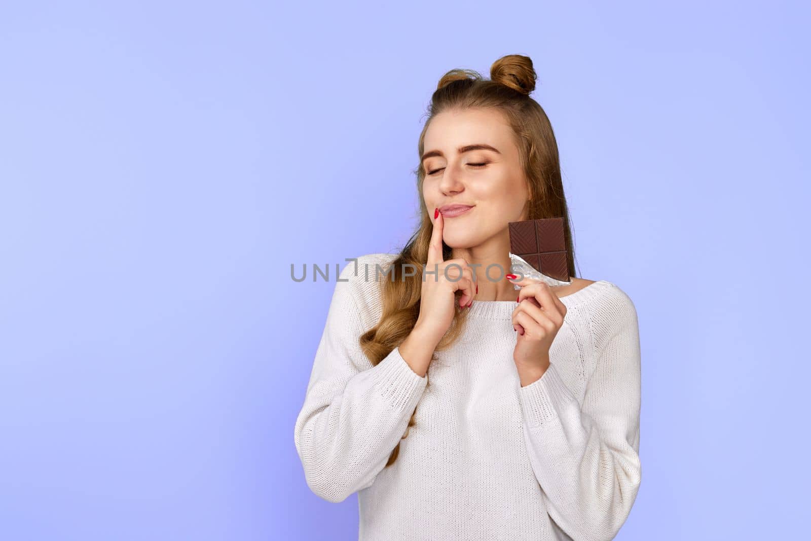 lovely pretty charming cute dreamy woman enjoying dark chocolate isolated on pastel violet background. copy space