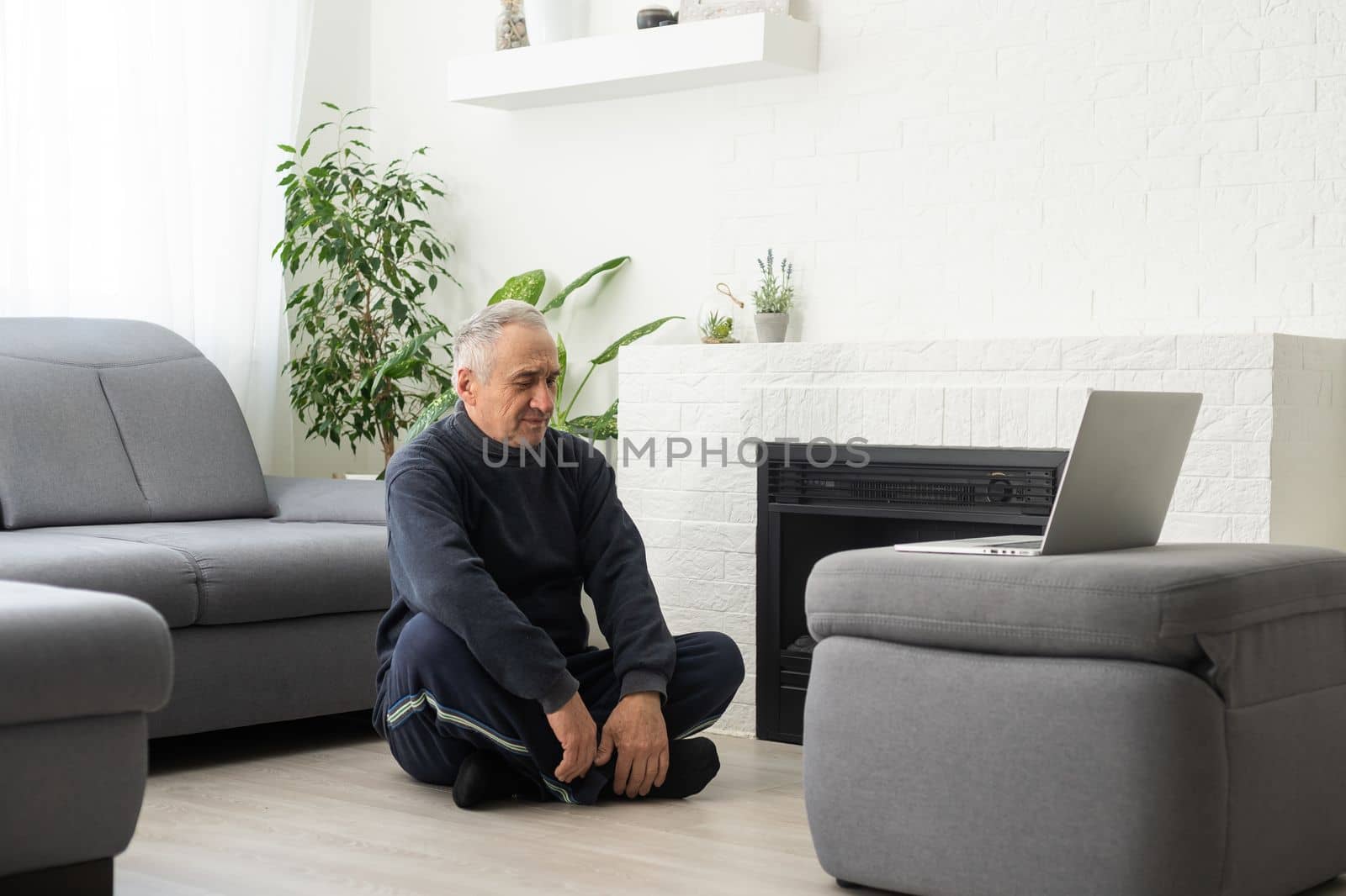 Online workout. elderly man doing exercise with online tutorial at home, panorama, free space by Andelov13