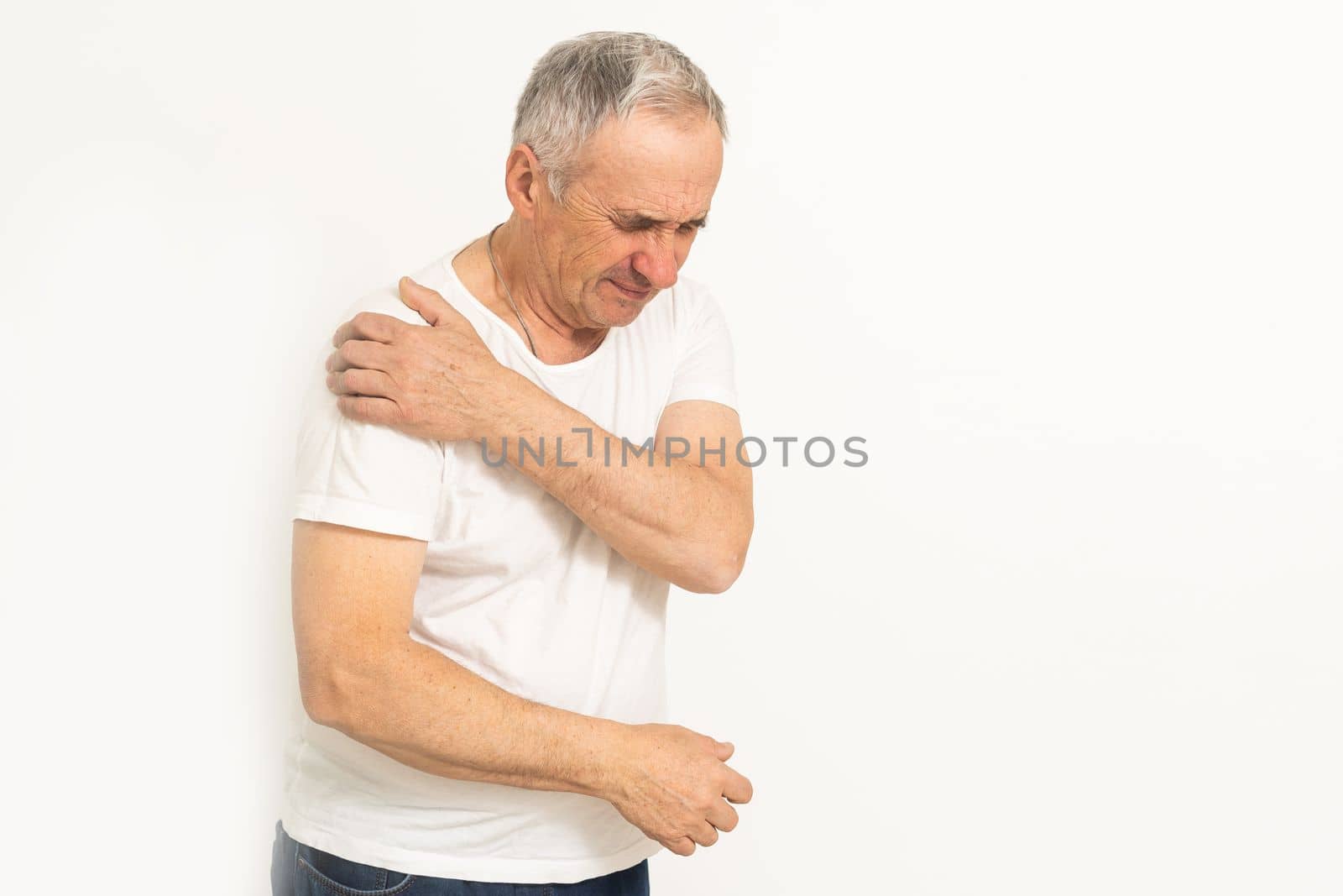 The elderly man suffering from the pain in this man's shoulder was extremely painful and held his shoulder.