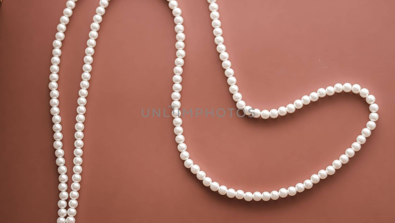 Pearl jewellery necklace on brown background.
