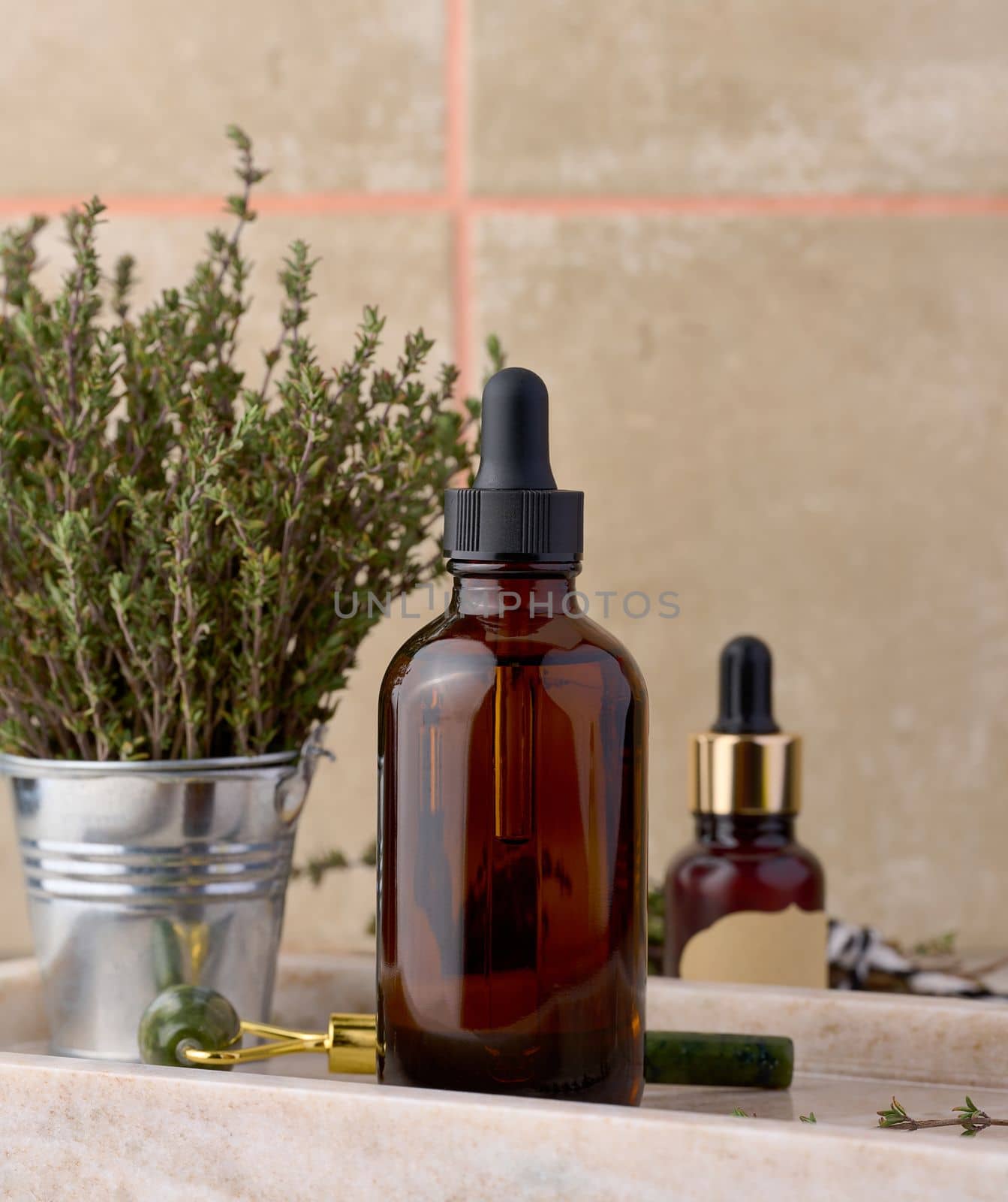 Thyme essential oil in glass bottle with dropper and fresh thyme sprigs on table, cosmetic ingredient by ndanko