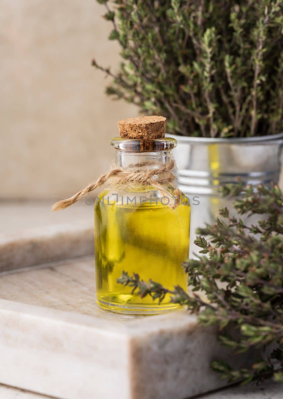 Thyme essential oil and fresh thyme sprigs on table, ingredient for cosmetics and cuisin by ndanko