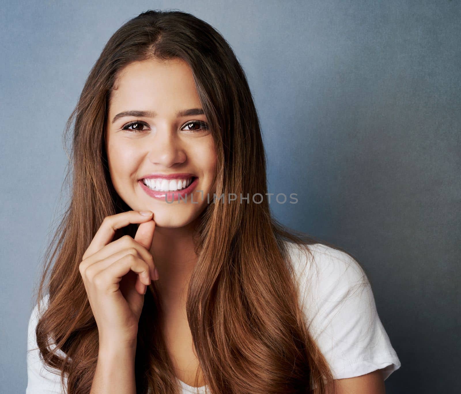 Its plain confidence. Studio shot of an attractive young woman posing against a gray background