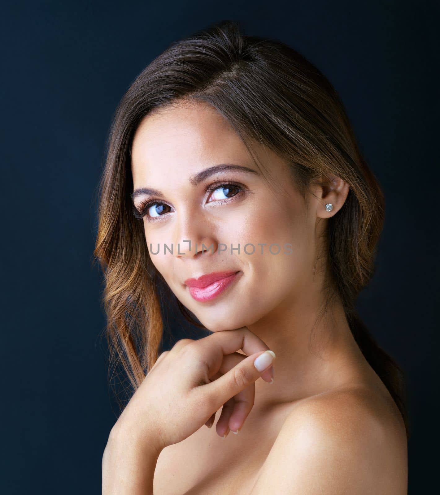 Embrace a fresh face. Portrait of a beautiful young woman posing against a dark background. by YuriArcurs