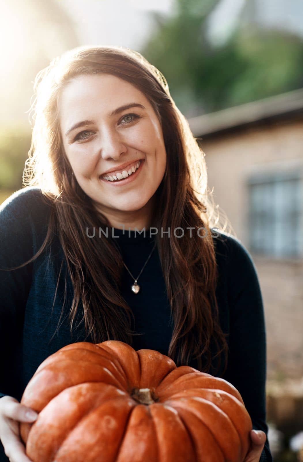 My favourite holiday is coming. Cropped portrait of an attractive young woman holding a pumpkin outside. by YuriArcurs