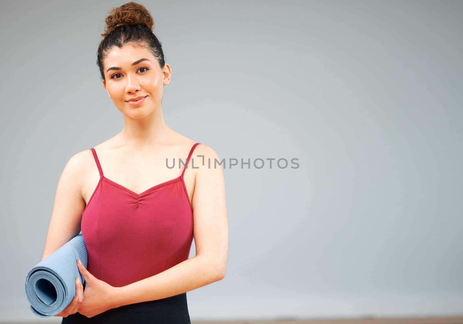 Ready to get my stretch on. a woman holding a yoga mat about to take a class