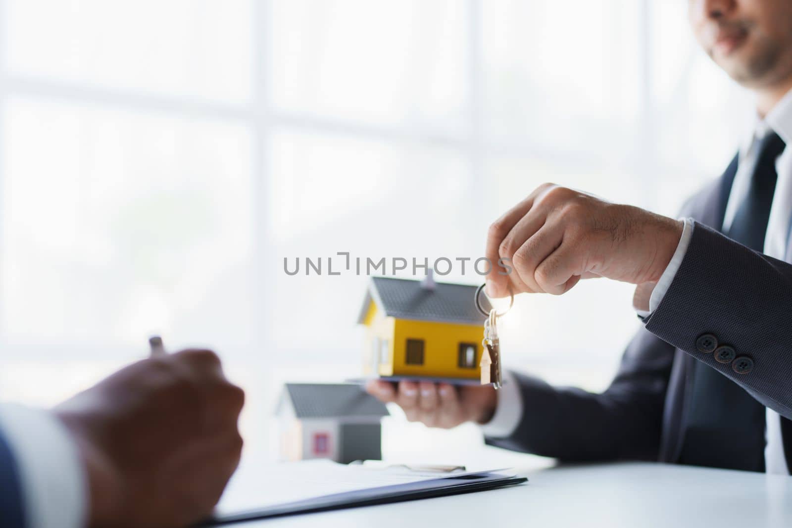 Real estate company to buy houses and land are delivering keys and houses to customers after agreeing to make a home purchase agreement and make a loan agreement. by Manastrong