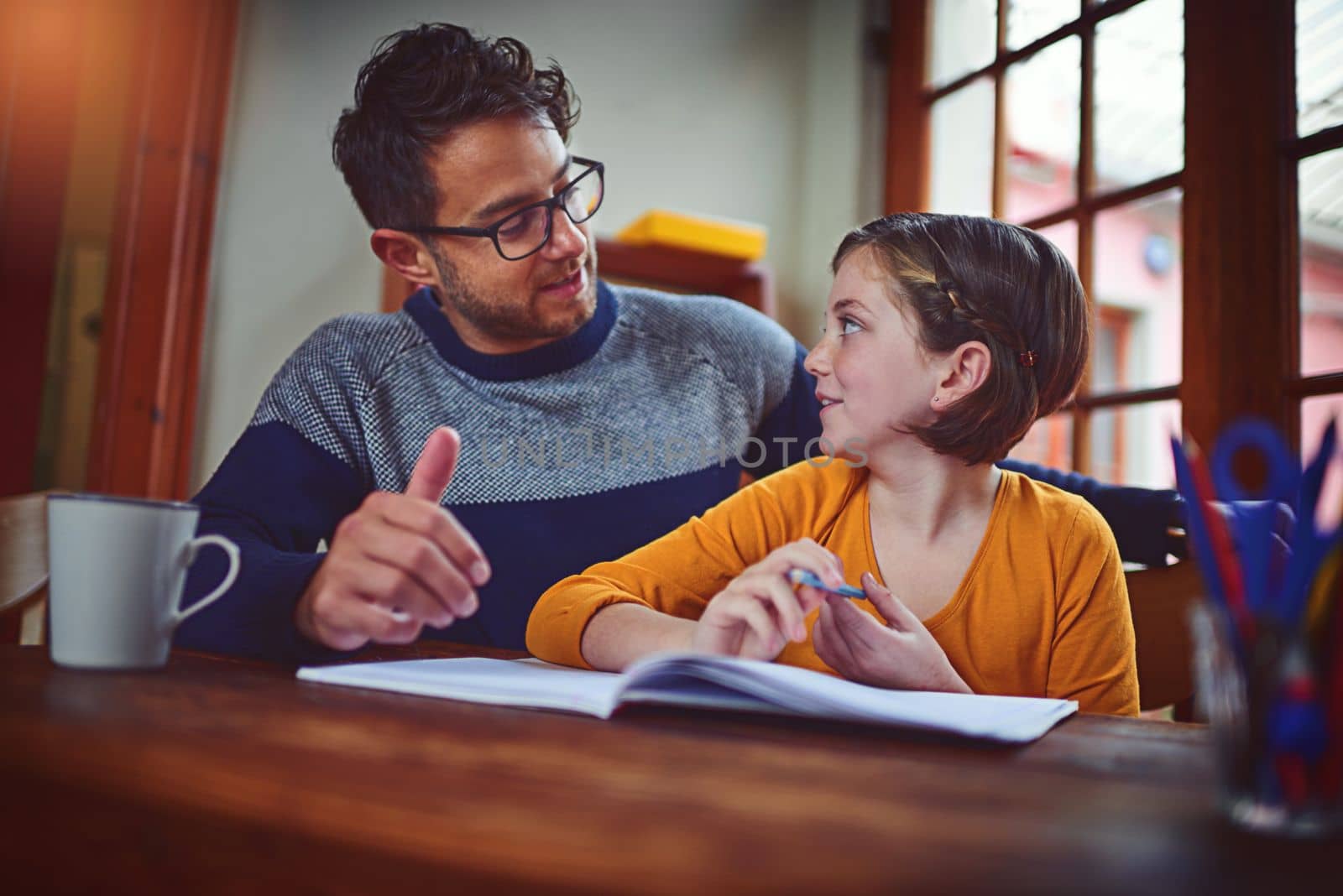 Youre such an expert, Dad. a father helping his little daughter with her homework. by YuriArcurs