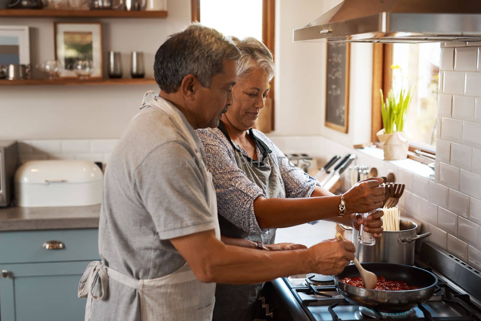 Salt isnt the only special ingredient. a happy mature couple cooking a meal together at home. by YuriArcurs