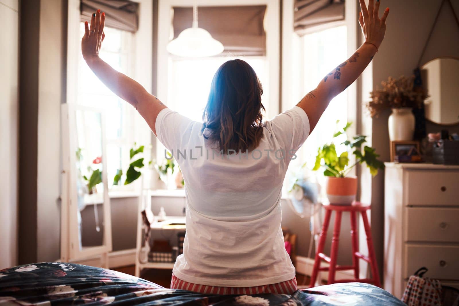 Lets start this day. Rearview shot of a young woman stretching at home