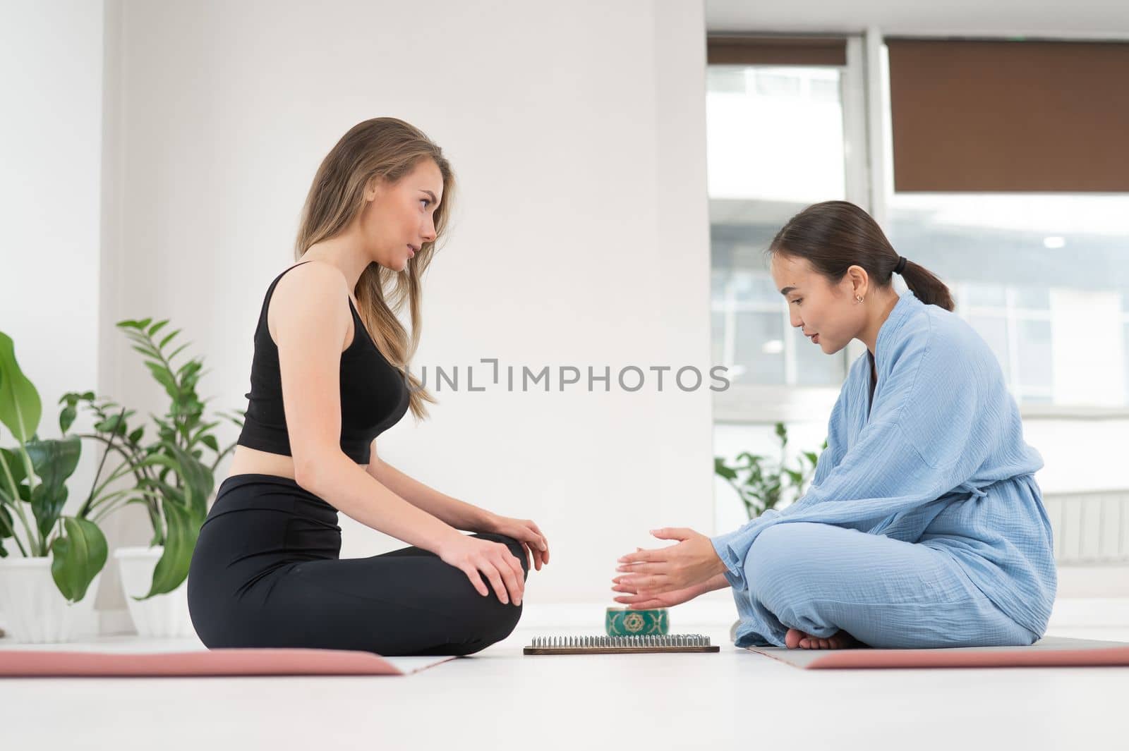 Caucasian and Asian women getting ready to stand on sadhu boards