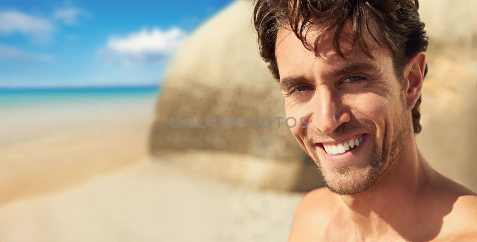 The beach is his happy place. Cropped portrait of a handsome man on a tropical beach. by YuriArcurs