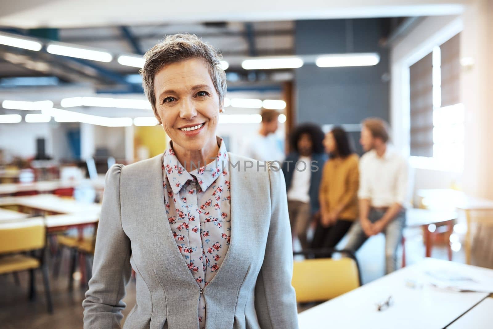 I couldnt have asked for a better group of employees. Cropped portrait of an attractive mature businesswoman in the office with his colleagues in the background. by YuriArcurs