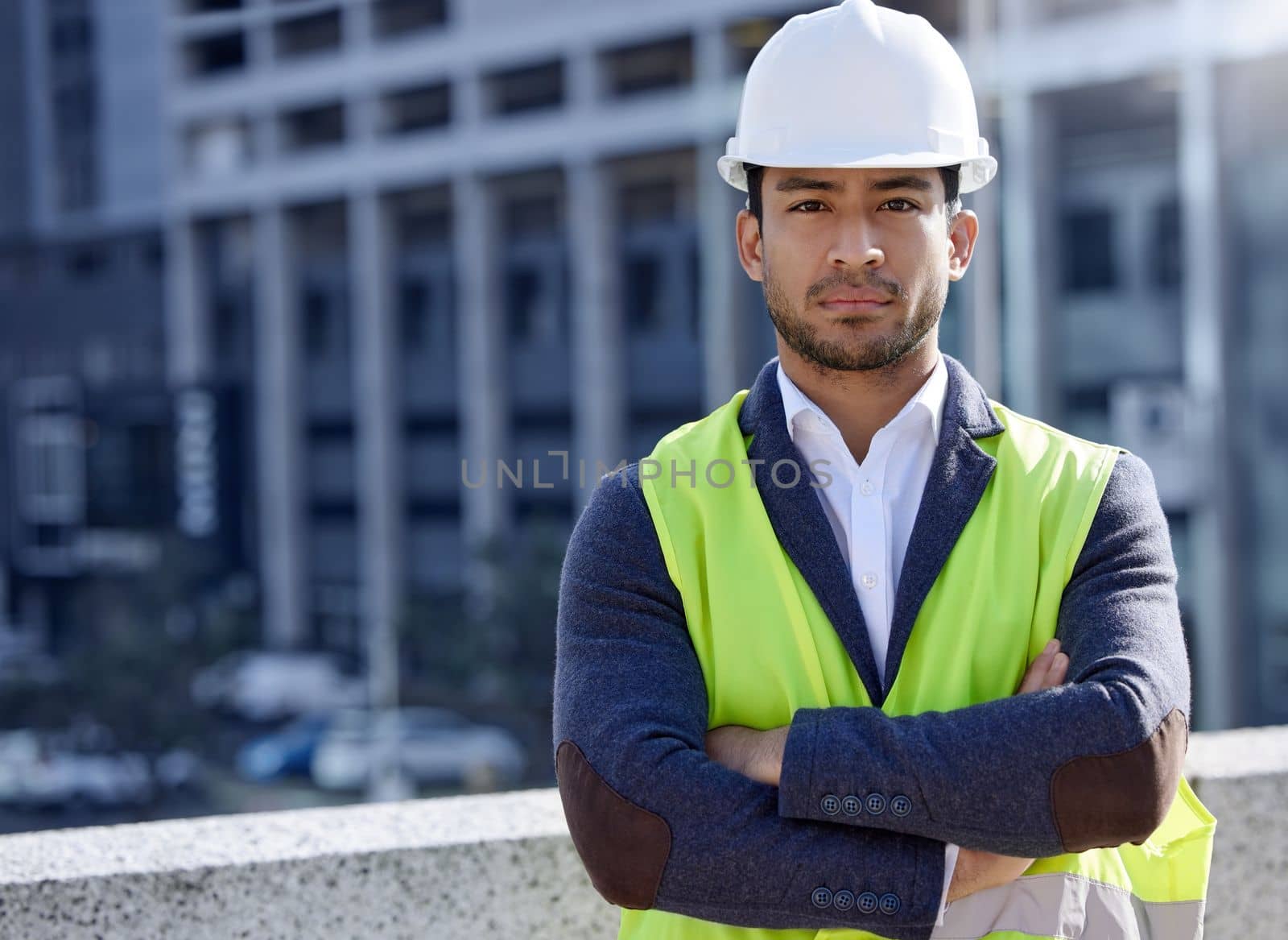 Focus and determination will get the job done. a young businessman working on a construction site. by YuriArcurs