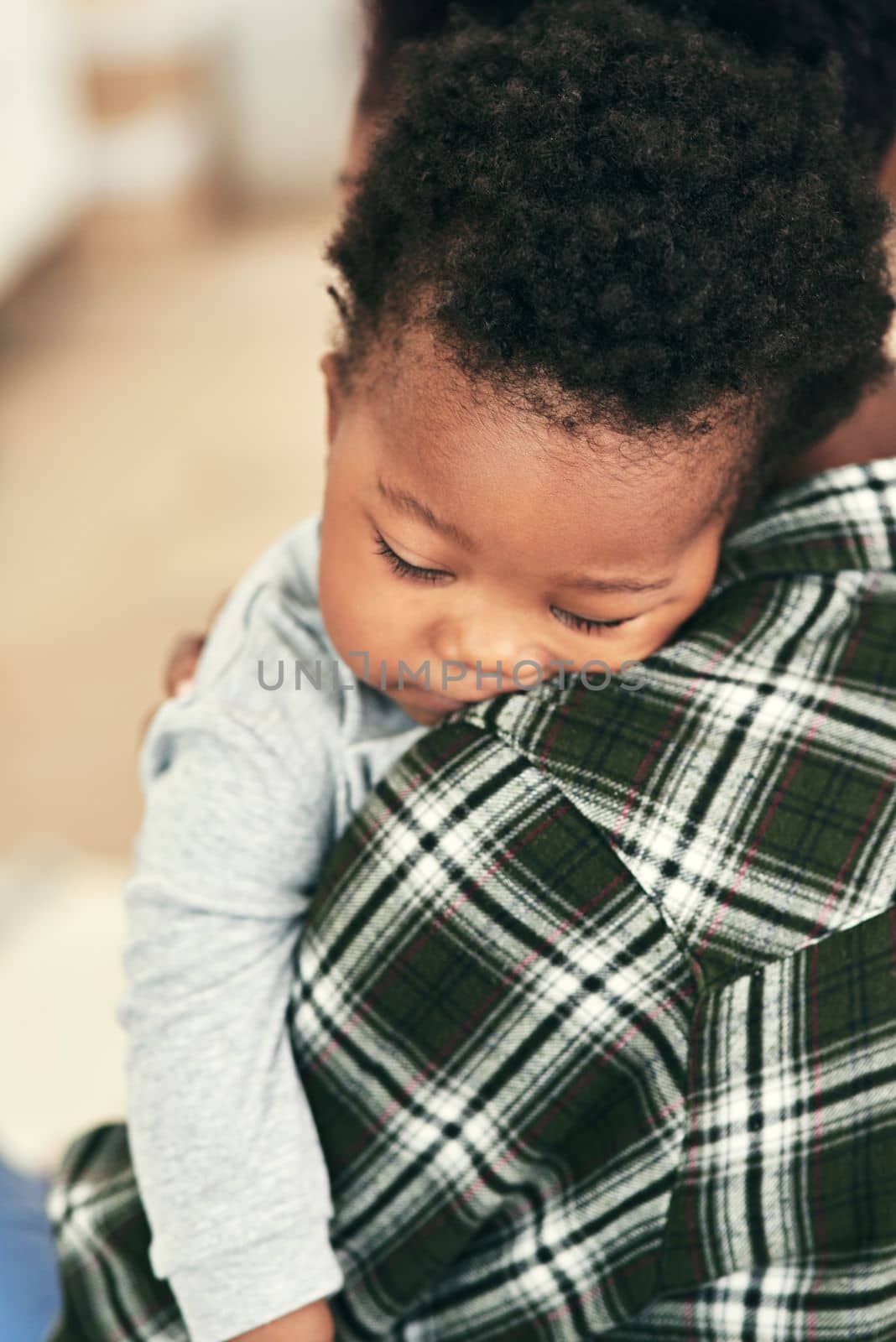 Sleeping soundly in his mothers arms. an adorable baby boy falling asleep on his mothers shoulders