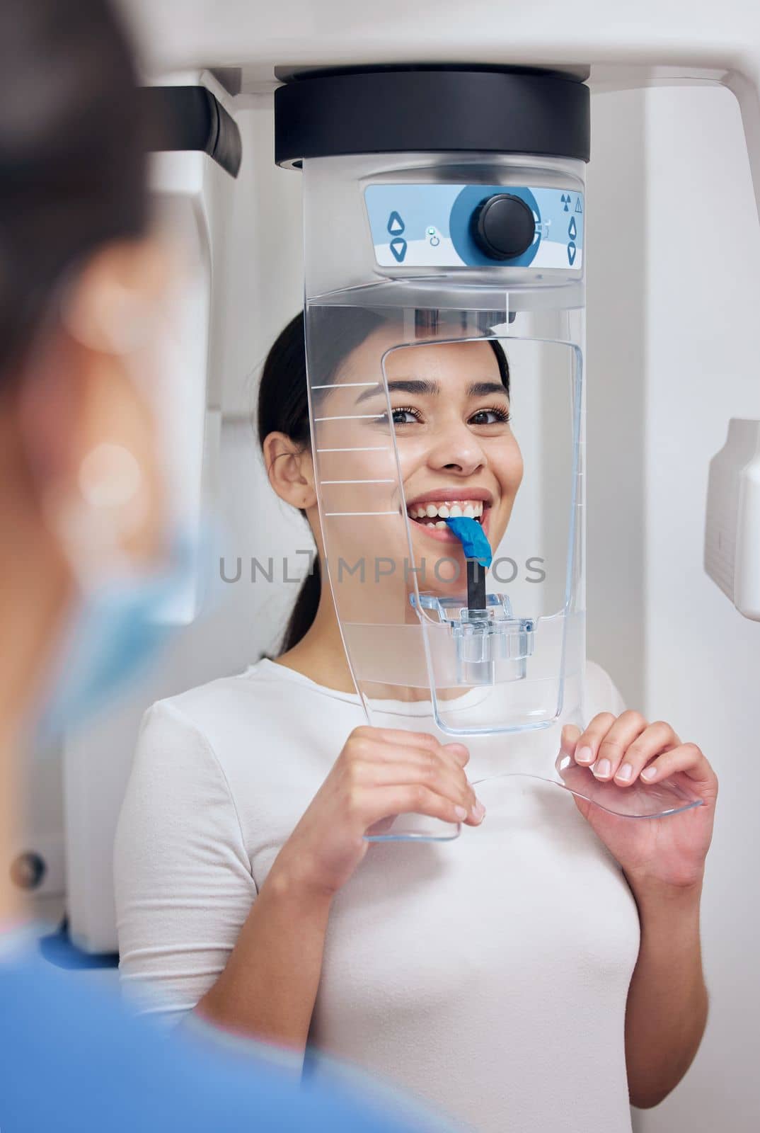 This always feels so awkward. a young woman getting her teeth scanned for a mold at the dentists office. by YuriArcurs