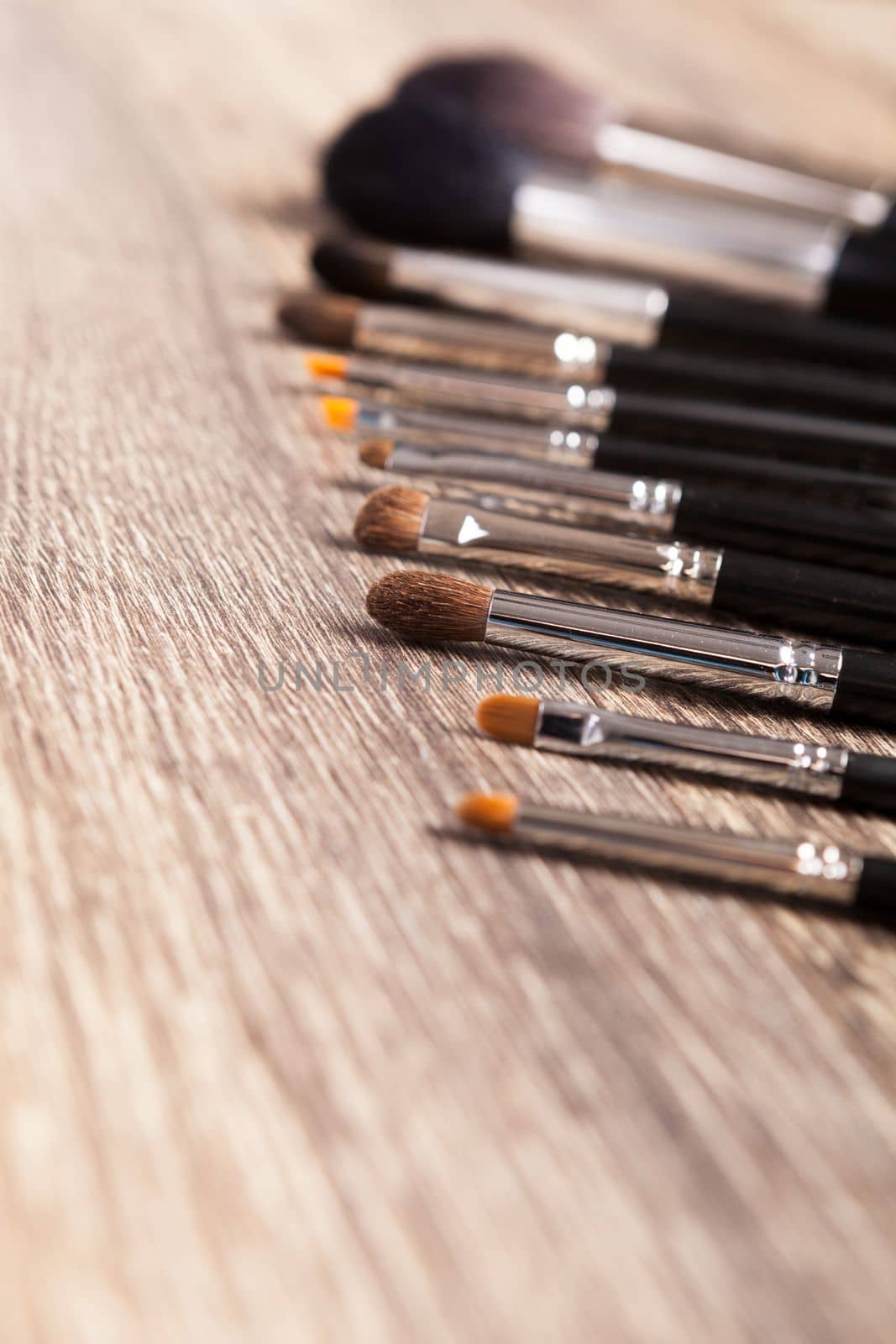 Professional make-up brushes on wooden background by DCStudio