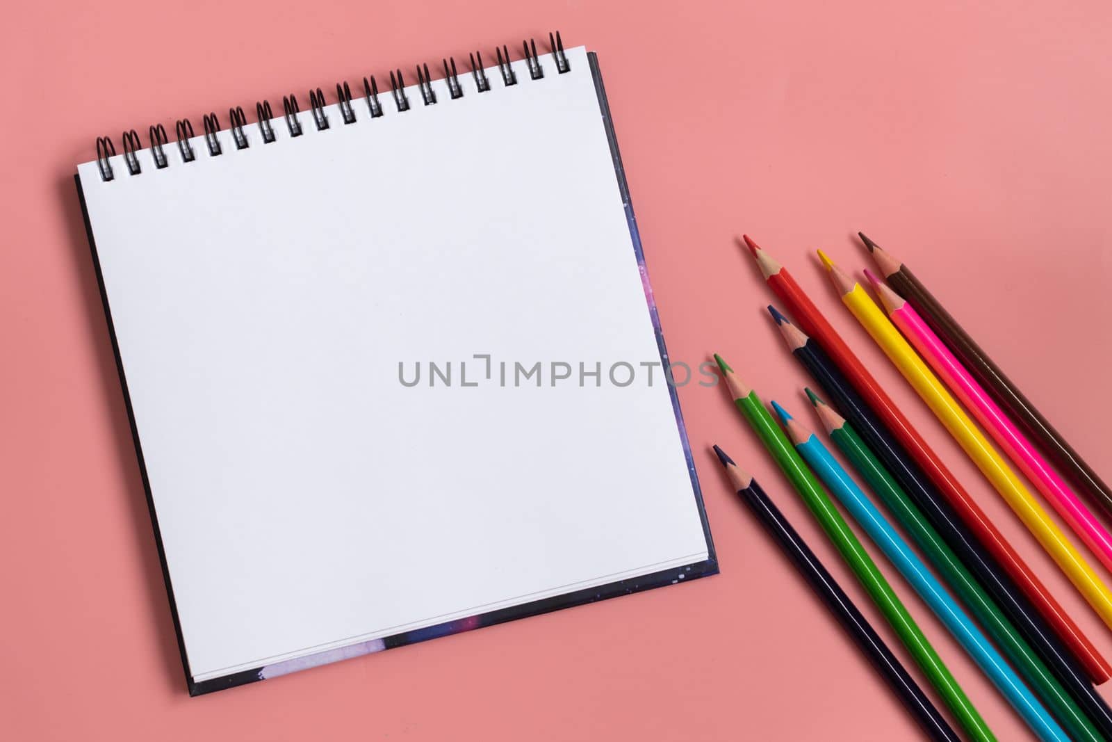 Back to school concept. Colorful crayons and white album on pastel pink. Copy space. Top view. by Ri6ka