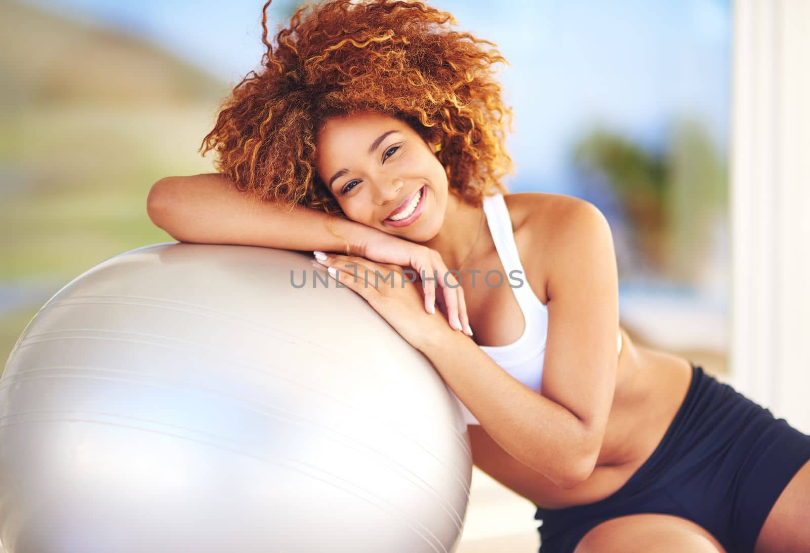 I lean on this ball for happiness. a young woman leaning against her exercise ball