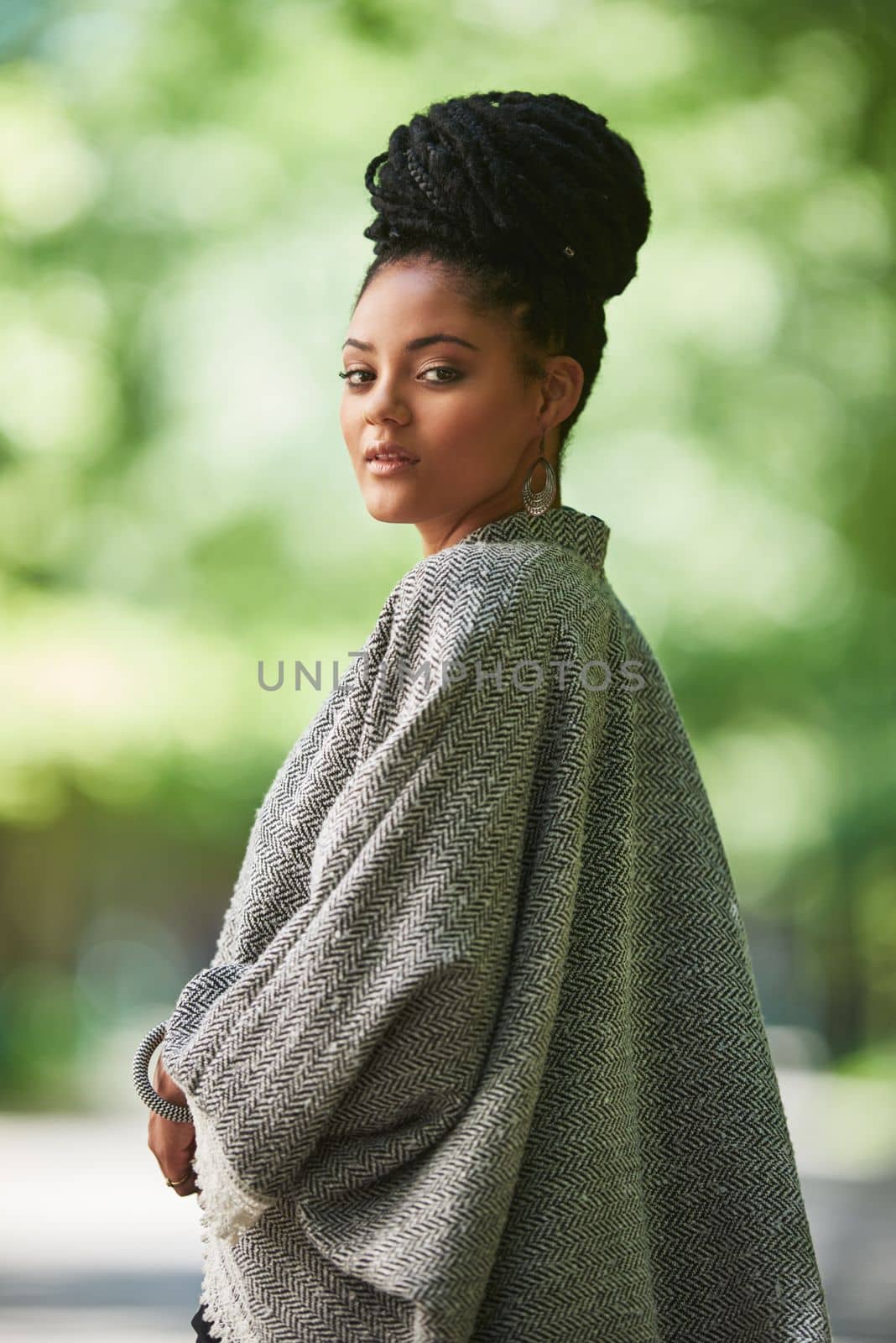 She stays on top of the latest trends. Portrait of an attractive young woman posing outdoors. by YuriArcurs