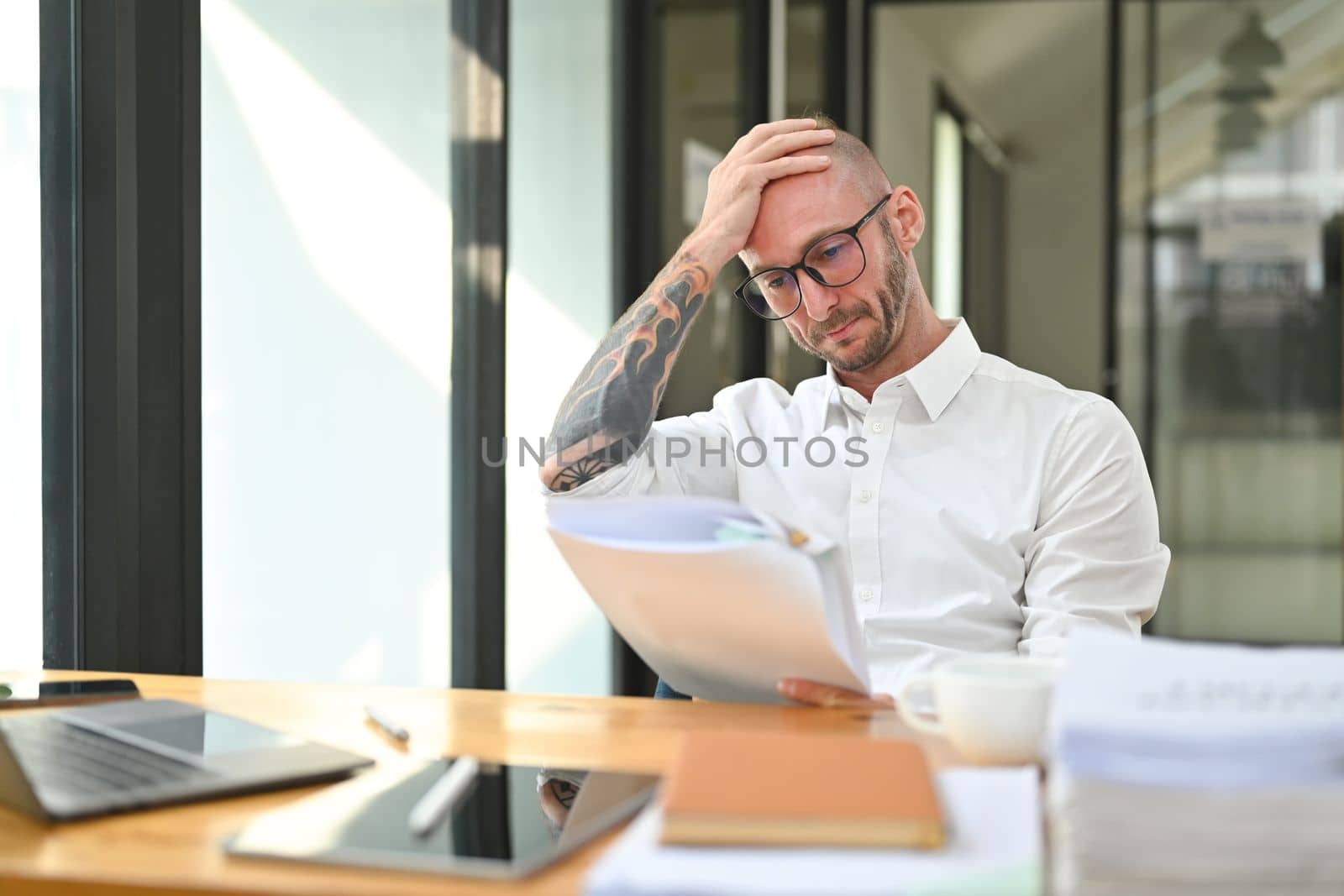 Frustrated adult man office worker holding her head in hands, feeling distressed anxious with work deadline.