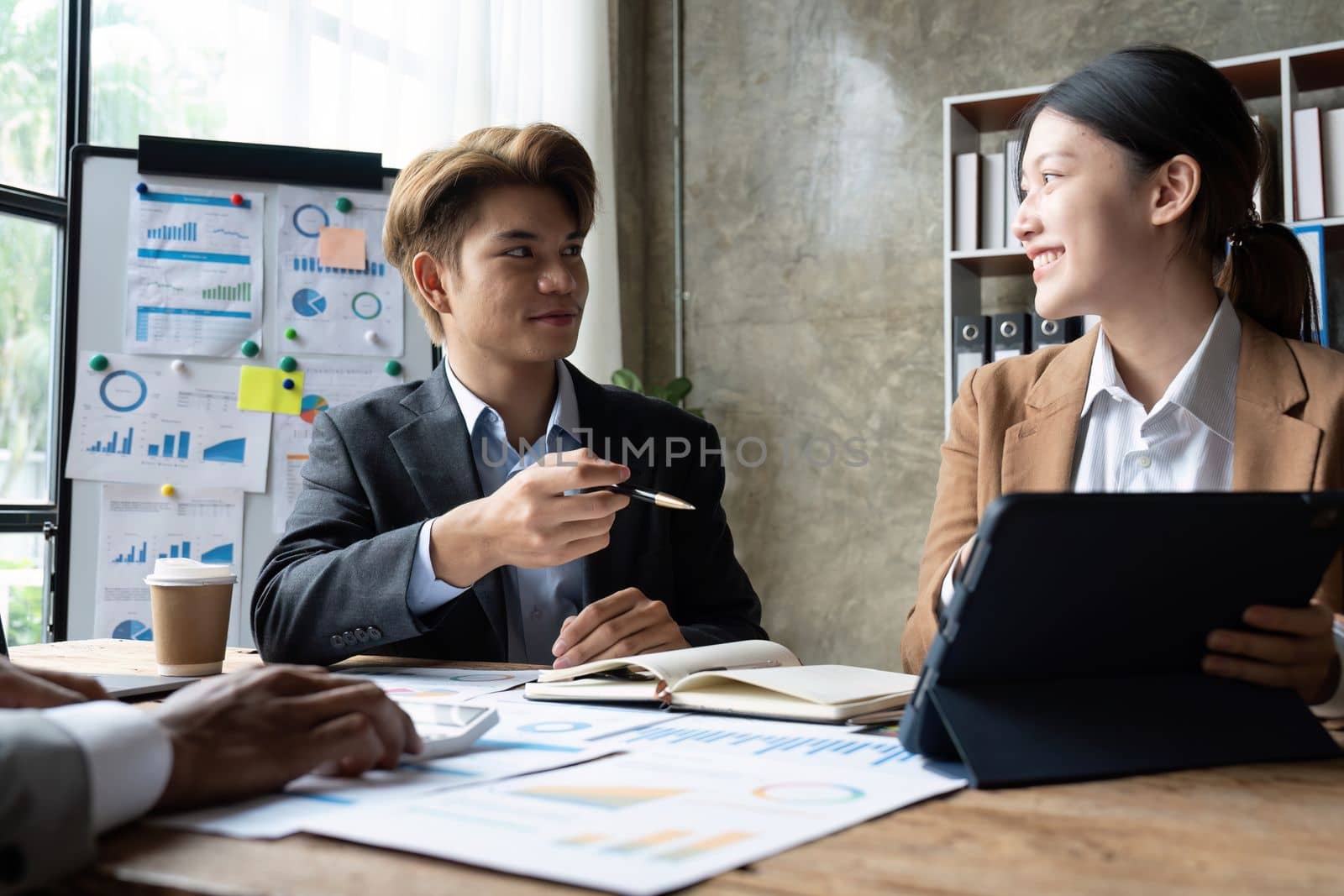 Business People Meeting using laptop computer, calculator, stock market chart paper for analysis planning to improve quality next month. Conference Discussion Corporate Concept.