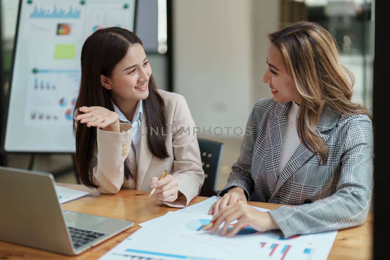 Financial analysts analyzing business reports on planned investment projects during corporate meeting discussions showcase successful teamwork with marketing plan, computers and calculators to work.