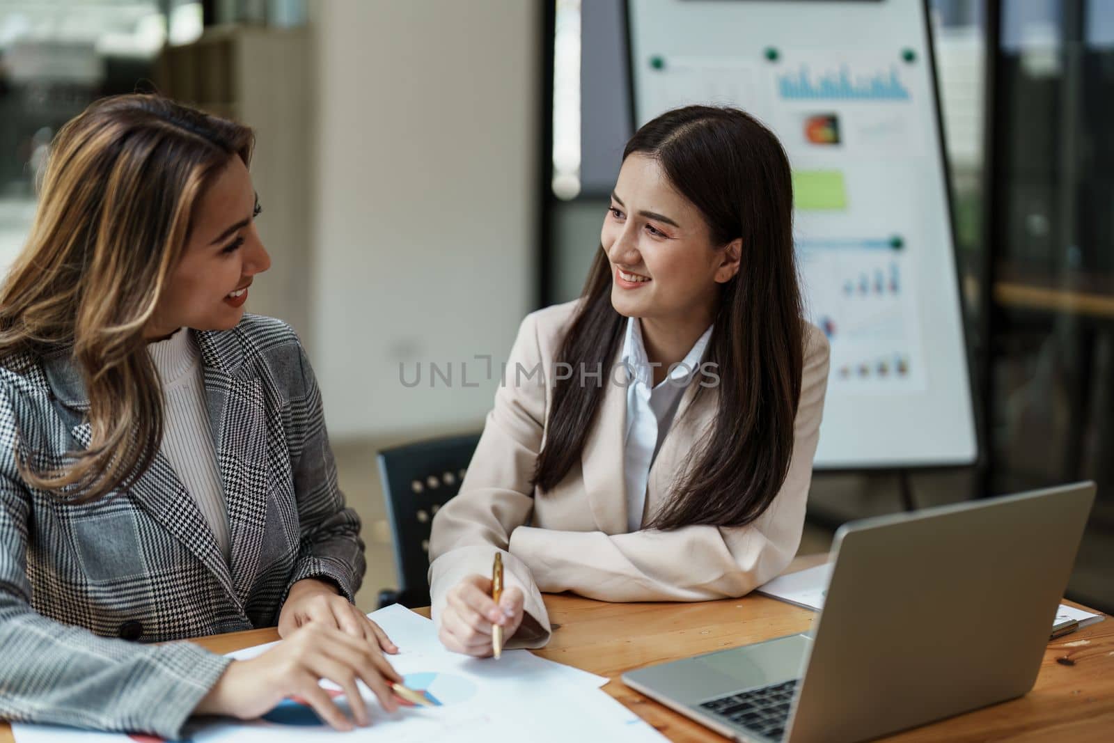 Financial analysts analyzing business reports on planned investment projects during corporate meeting discussions showcase successful teamwork with marketing plan, computers and calculators to work.