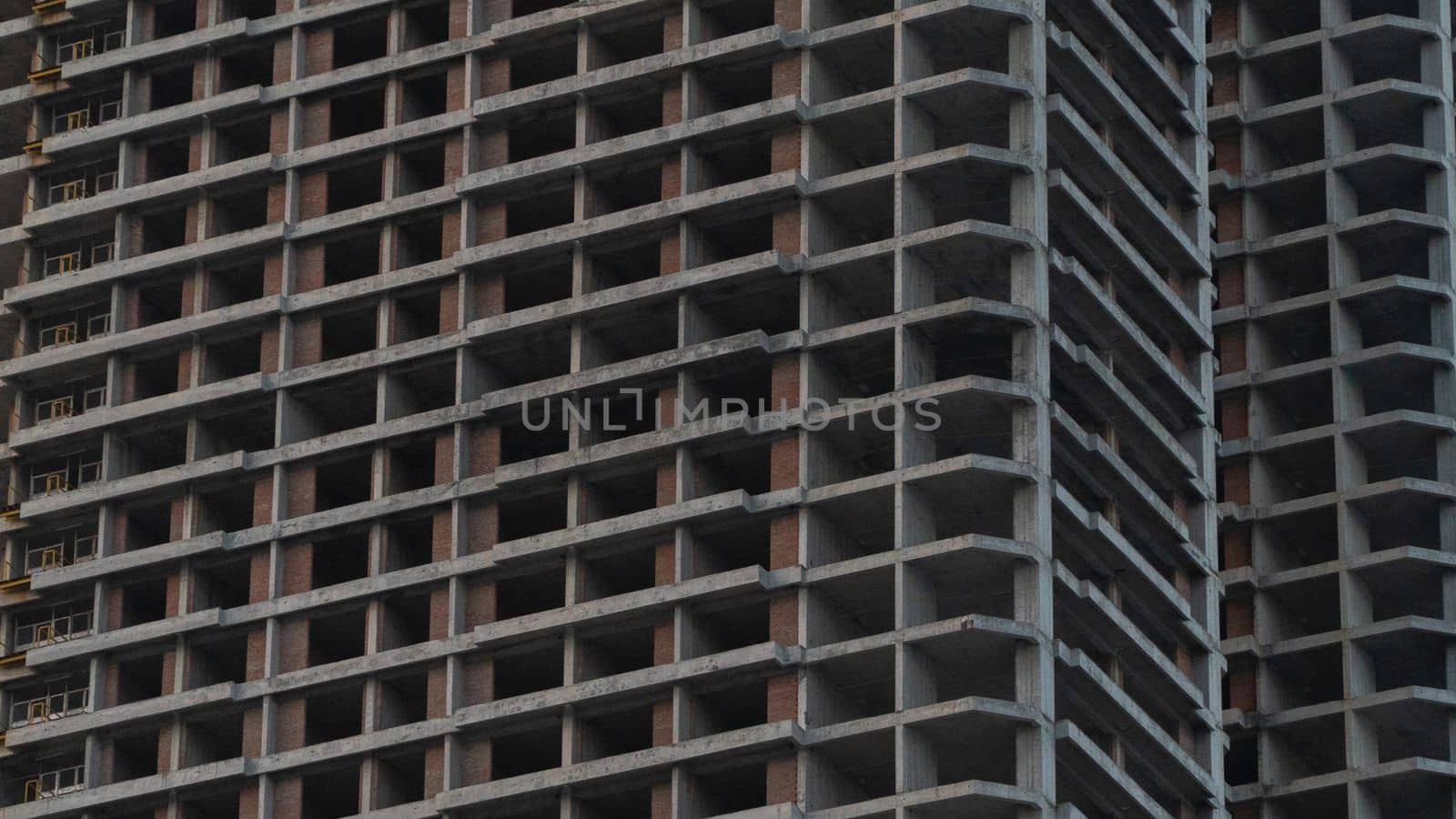 Construction of a skyscraper, unfinished frame of concrete building background by voktybre