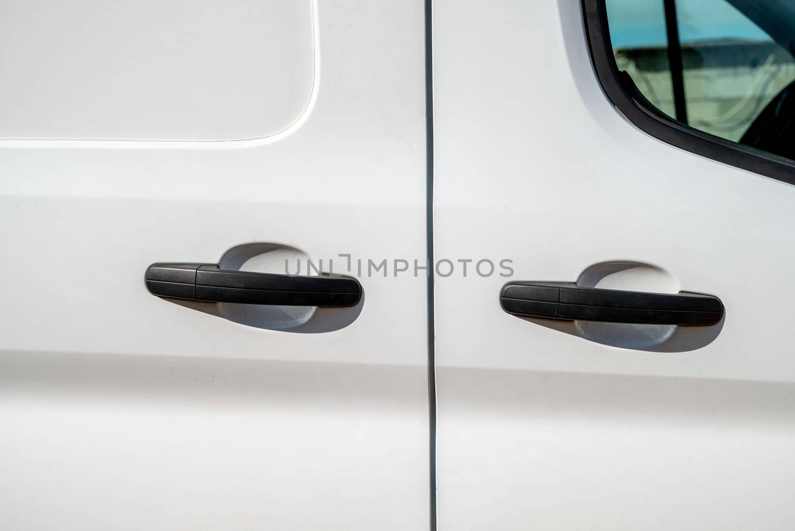Black handle of sliding door of white colored van