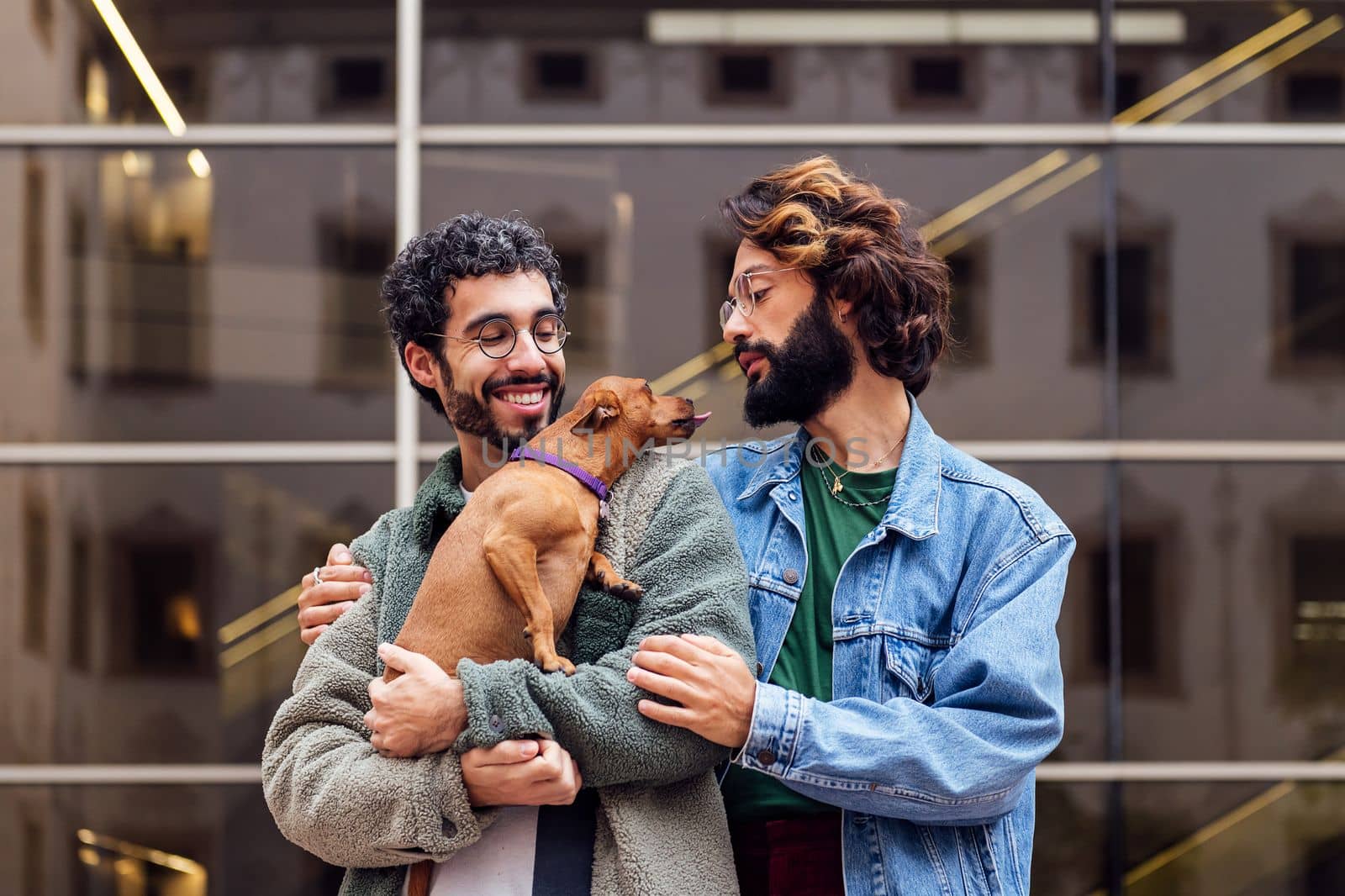 couple of men embracing with their loving little dog by raulmelldo