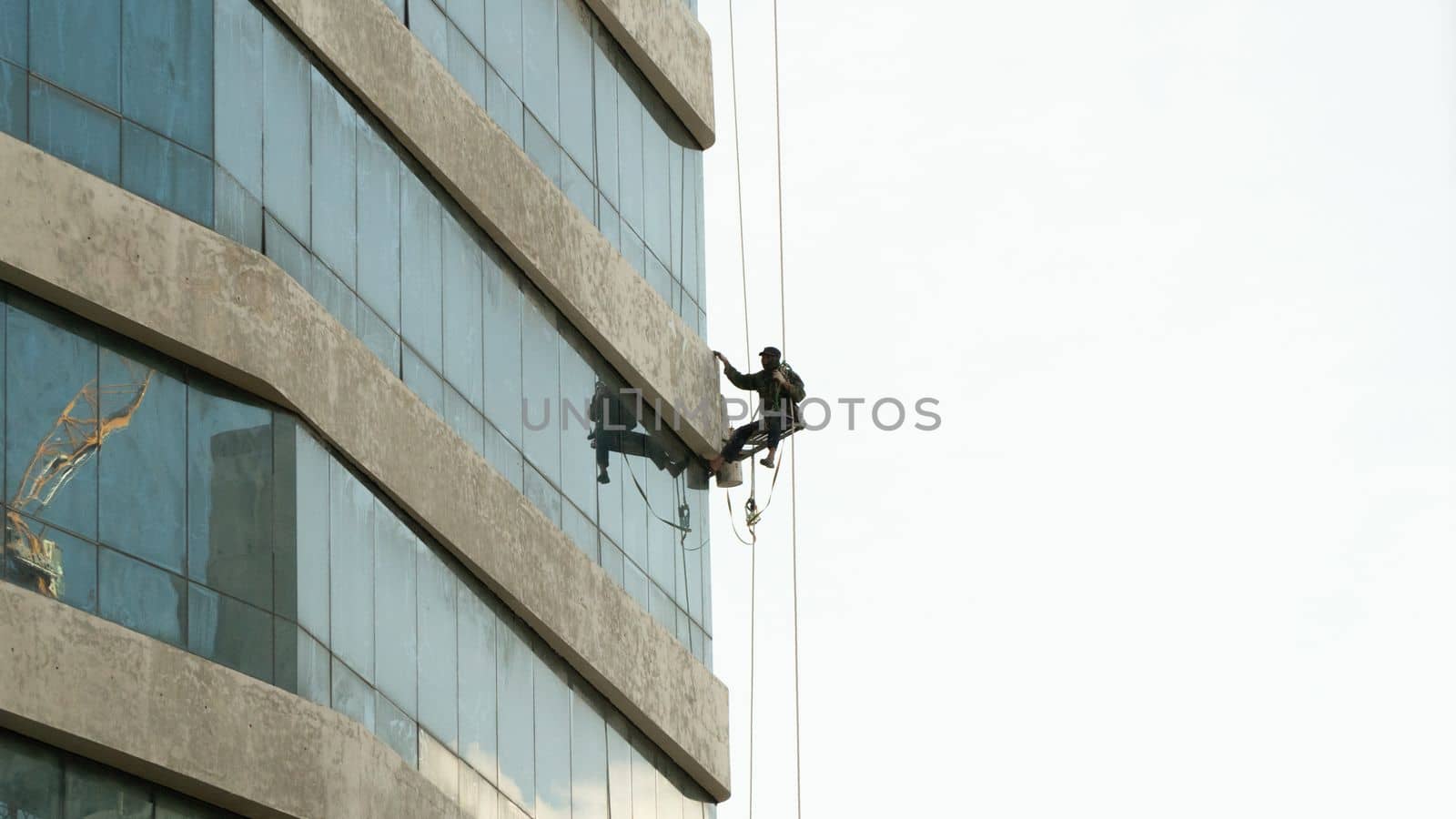 High-altitude work of an industrial climber on a building. High quality photo