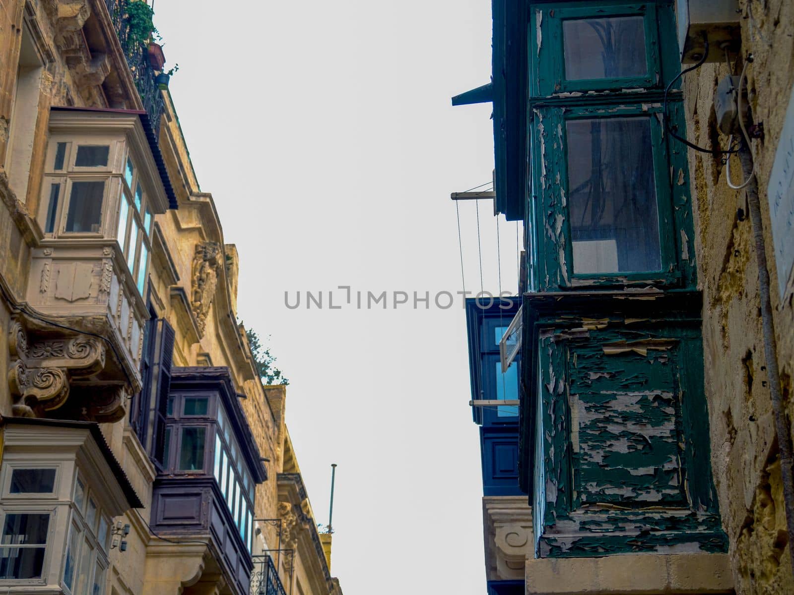 Fragment of the building's facade with traditional wooden ornate balconies painted in Valletta, Malta. High quality photo