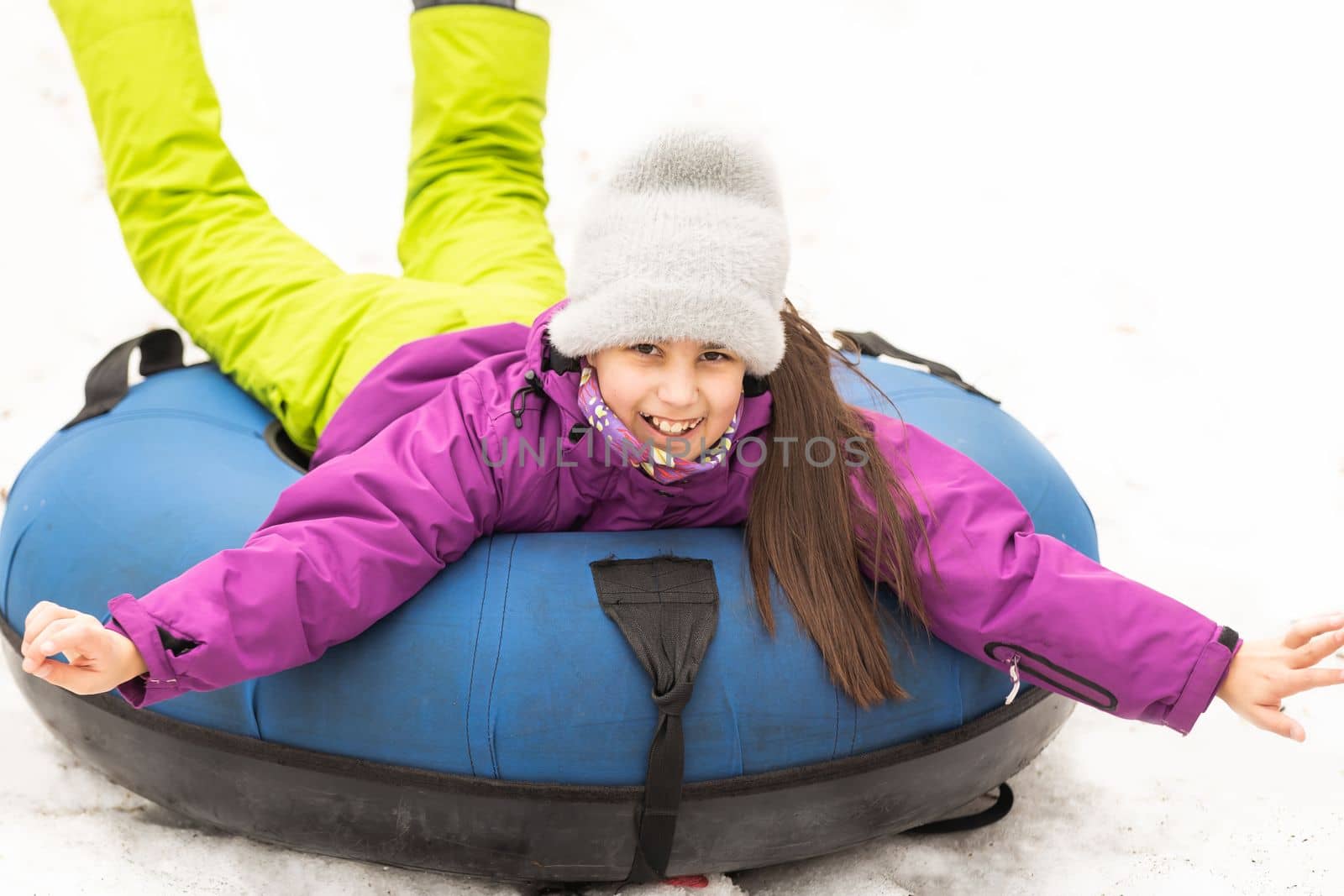 Children ride on tubing. Winter entertainment. Tubing. People roll on the slides