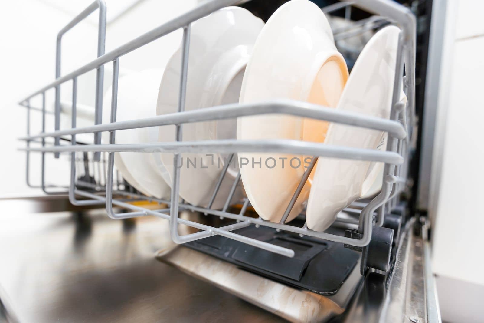 dishwasher close-up with washed dishes, easy to use and save water, eco-friendly, built-in kitchen dish washing machine by Andelov13