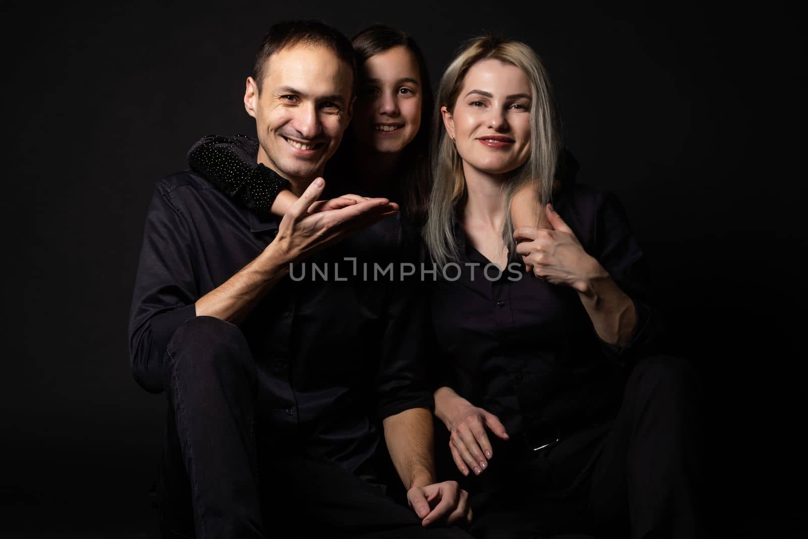 happy family mother, father, daughter on a black background.