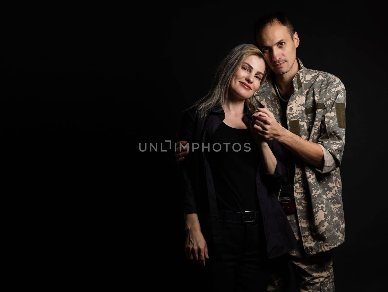 military man and his wife on a black background.