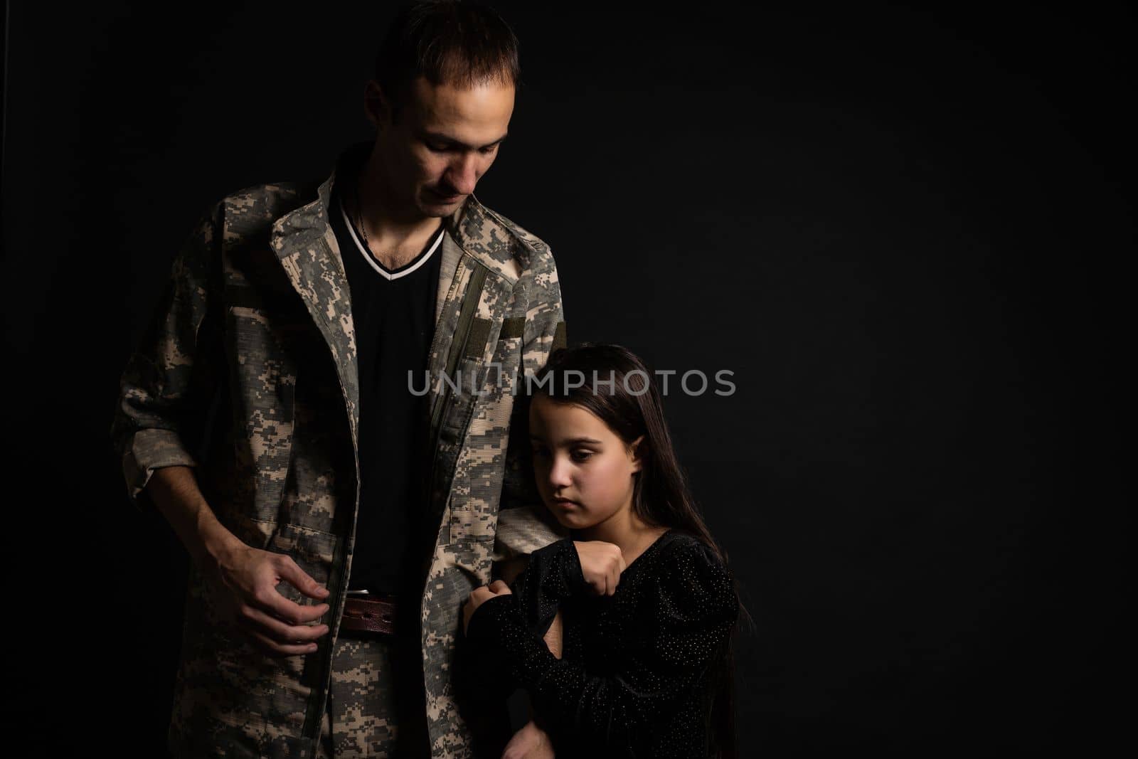Masculine sad military man hugging her upset daughter indoors by Andelov13