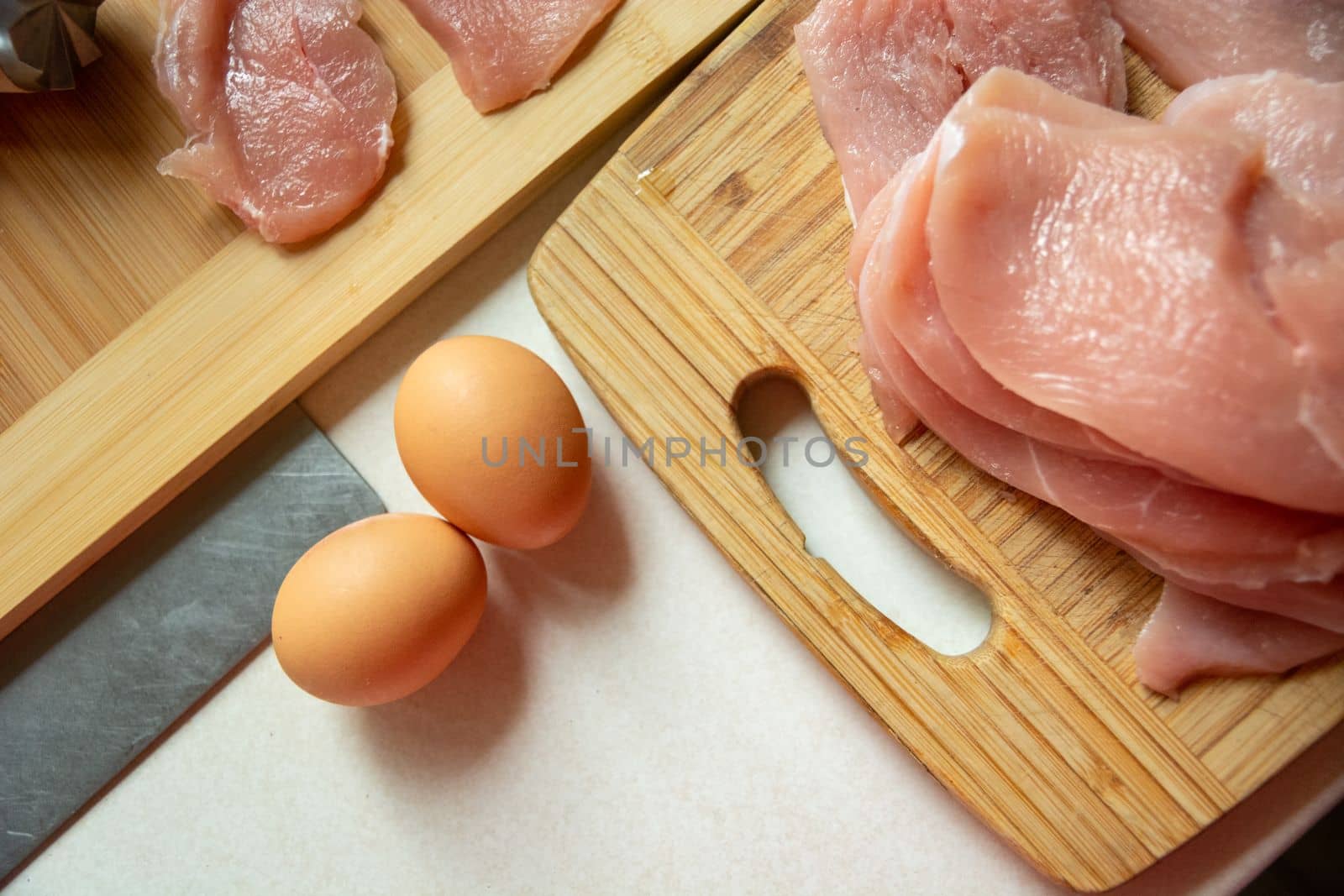 Eggs and raw meat on a kitchen board, top view