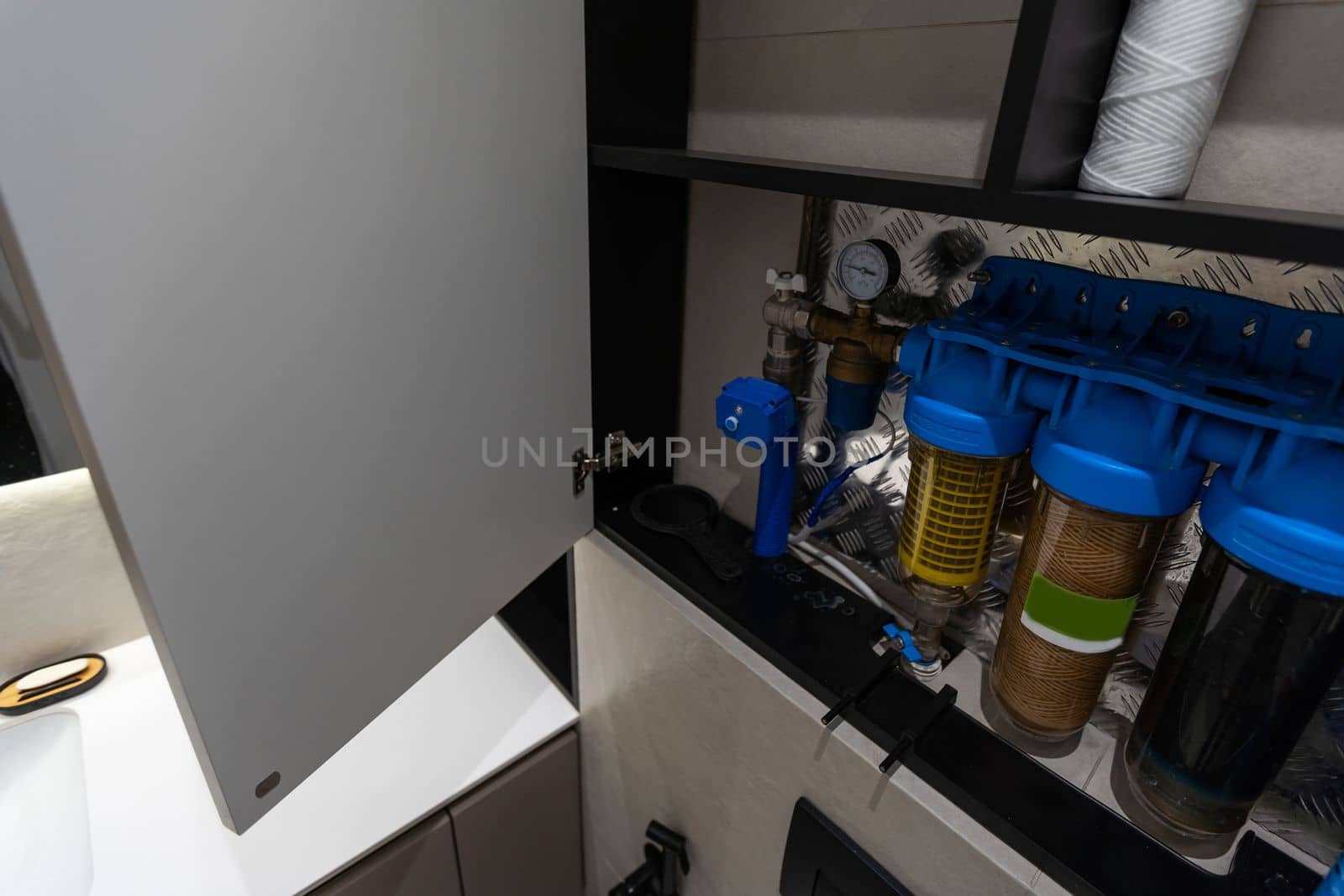 Replaceable cartridges in the water filter system. Water filtration system with replaceable cartridges. A system in the apartment with three tanks for cleaning tap water.