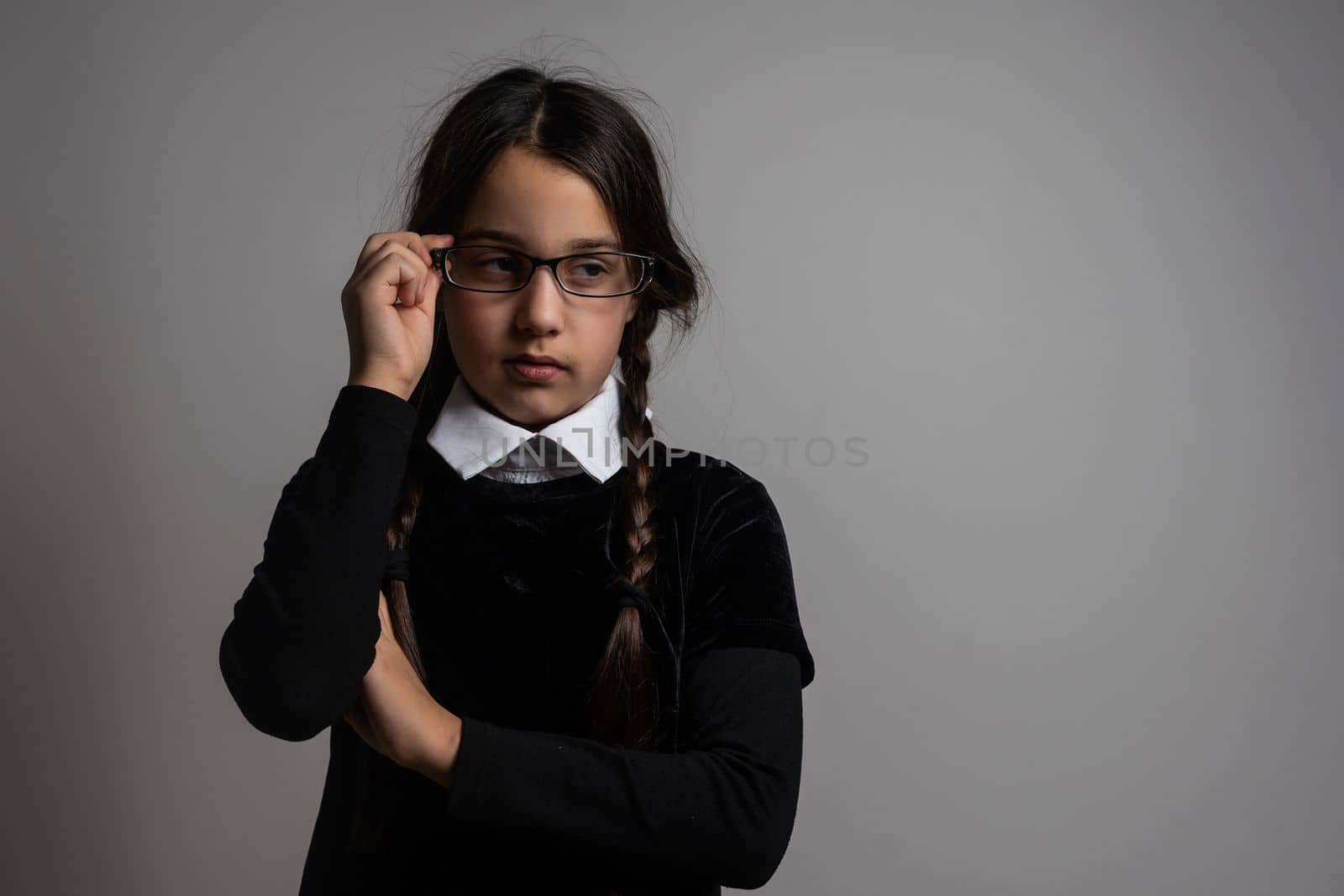 A girl with braids in a gothic style on a dark background